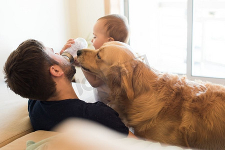 家庭有与一个奶瓶的乐趣-父亲、婴儿和狗！  