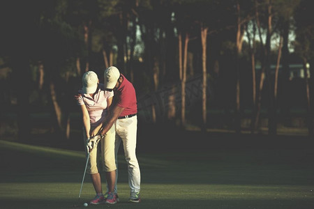 男高尔夫教练教女高尔夫球手，私人教练在高尔夫球场授课。高尔夫球说明