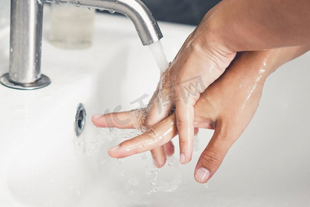 冠状摄影照片_洗手以预防新型冠状病毒病2019或COVID—19。人们在洗手池洗手以清除病毒感染。
