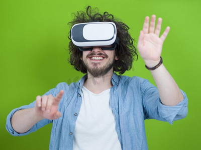 获得使用虚拟现实VR耳机眼镜的经验的愉快的人，在绿色背景隔绝