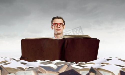 读书的书。戴眼镜的年轻人手里拿着打开的书