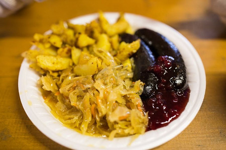 食物和饮食理念--红烧卷心菜、土豆和红莓酱香肠。盘中炖卷心菜和香肠配酱汁