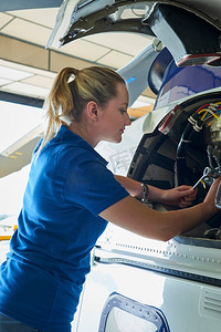 女航空工程师在机库的直升机上工作
