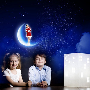 夜里做梦。可爱的小男孩和小女孩看着房子的模型