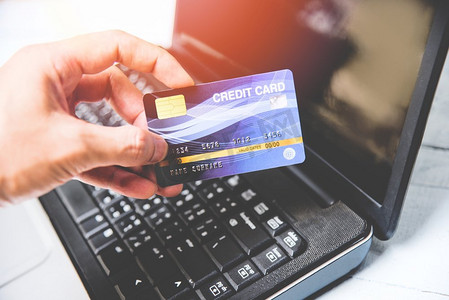 信用卡和使用膝上型电脑容易支付网上购物概念/电子卡在手网上支付