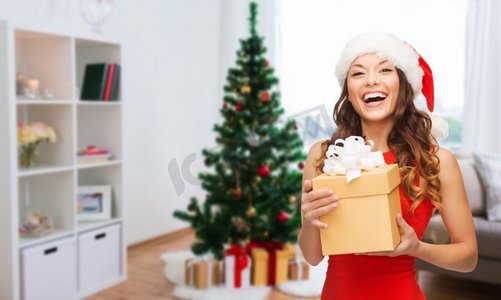 动态问好带字摄影照片_圣诞节、节日和人们的概念--戴着圣诞帽、带着礼物的微笑的女人。戴着圣诞帽的微笑着的女人带着圣诞礼物