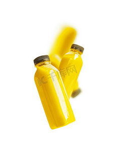 水果品牌摄影照片_飞扬的黄色奶昔或果汁瓶，白色背景。品牌文案空间