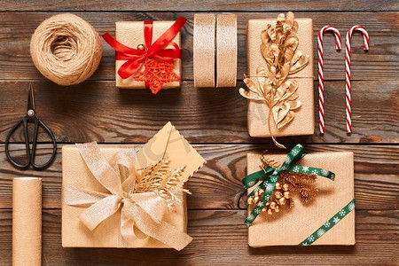 创意包装和装饰的圣诞礼物在木质背景的盒子里。从上面俯瞰。平躺着。