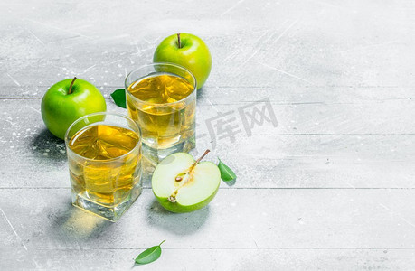 苹果汁在一个玻璃杯与新鲜苹果。在乡村背景下。苹果汁在一个玻璃杯与新鲜苹果。