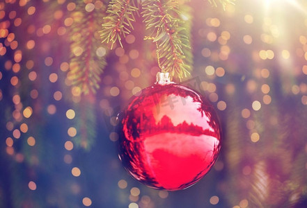 寒假和装饰概念--雪花覆盖的冷杉树枝上的红色圣诞球。红色的圣诞球在积雪的冷杉树枝上