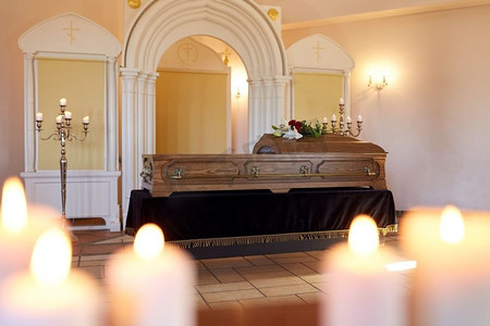 哀悼摄影照片_葬礼和哀悼概念-燃烧蜡烛和棺材在东正教教堂。燃烧的蜡烛和棺材在教堂在葬礼