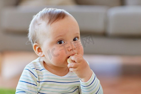 儿童米米摄影照片_童年，孩子和人的概念-男婴在家吃米饼。男婴在家中吃米饼