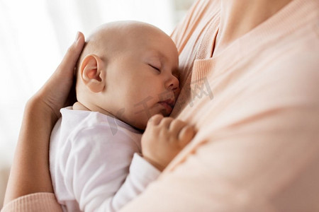 家庭、母亲和人的概念-母亲抱着睡着的小男婴的特写。母亲抱着熟睡的婴儿的特写