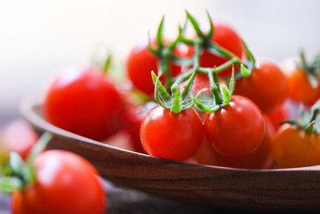吐鲁番西红柿摄影照片_新鲜的番茄樱桃有机/关闭成熟的红番茄木勺背景—选择性焦点