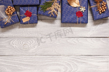 创意包装和装饰的圣诞礼物在白色木制背景的盒子里。从上面俯瞰。