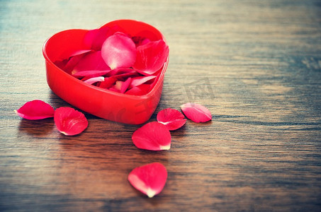 情人节爱心概念/打开红色心盒装饰的红色玫瑰花瓣在木背景 