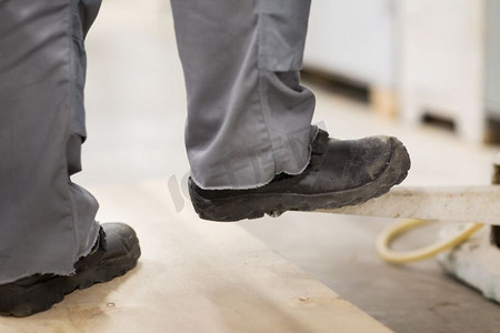 人、鞋和工作理念-穿着工作鞋的男工脚特写。穿着工作鞋的男工脚特写