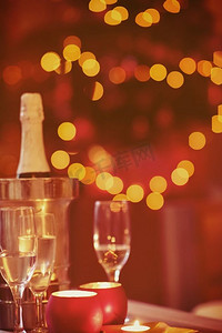 家里有香槟和玻璃杯，背景是圣诞树，新年蜡烛装饰。圣诞夜，家里有香槟和玻璃杯
