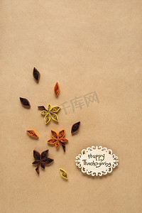 有创意的感恩节概念照片，树叶由纸制成，棕色背景。