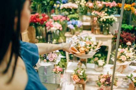 女性顾客选择鲜花准备花束。花卉生意，花店