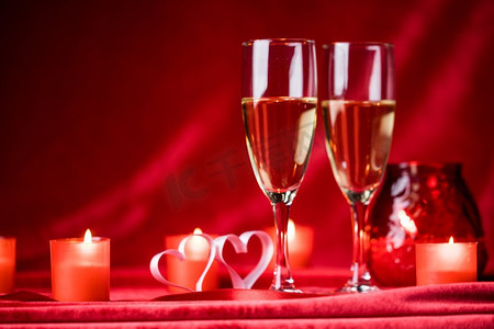 香槟和蜡烛。情人节庆祝活动，红丝上的香槟、蜡烛和心形图案