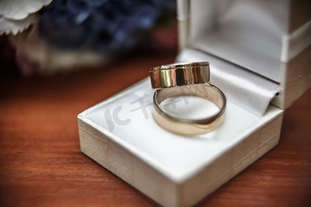 服装桌子摄影照片_结婚戒指和结婚花束一起放在桌子上