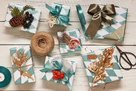 创意包装和装饰的圣诞礼物在白色木制背景的盒子里。从上面俯瞰。