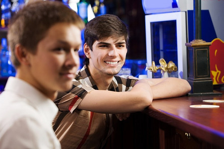 运动酒吧。两个年轻人坐在酒吧里聊天