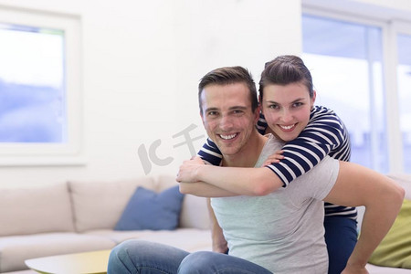 快乐的年轻人背着他的女朋友在家