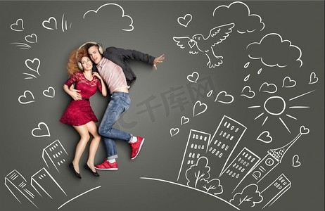 情侣浪漫背景摄影照片_幸福的情人节爱情故事概念一对浪漫的情侣共享耳机，在城市背景下听着粉笔画的音乐。