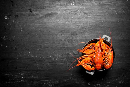 在碗里煮小龙虾。在黑色黑板上..在碗里煮小龙虾。