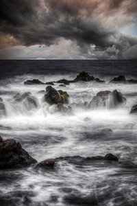 海洋中的风暴。水中的石头是在长时间曝光后拍摄的。海洋中的风暴。