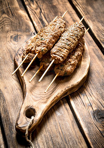 烤肉串在板上。在一张木桌上。烤肉串在板上。