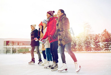 朋友友摄影照片_人、冬、友、动、闲理念--户外溜冰场上滑冰快乐朋友。快乐的朋友们在户外溜冰场滑冰