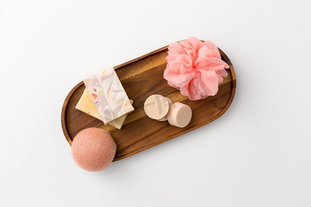 海棉宝宝摄影照片_美容，水疗和健康的概念—近距离制作的肥皂条，海棉海绵和亚麻木托盘。手工制作的肥皂、海绵和海绵放在木制托盘上