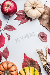 美丽的秋天背景，白色桌子背景，俯视，边框，五颜六色的南瓜，苹果和秋叶