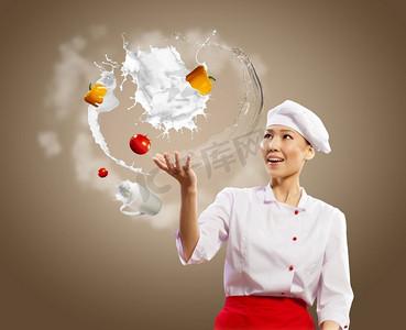 杂耍女厨师。在彩色背景下玩杂耍的亚洲女厨师