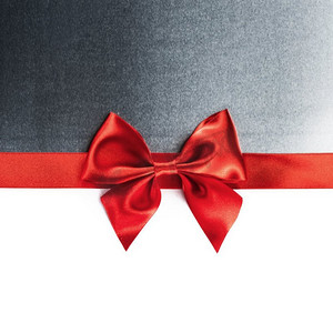 白色上有红色的礼物蝴蝶结。红色礼物彩带蝴蝶结和白色背景下隔离的金属