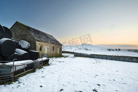 山顶云摄影照片_日出时分，美丽的白雪覆盖着山顶的冬景。风景画。英国山顶地区日出时分白雪覆盖的冬季景观