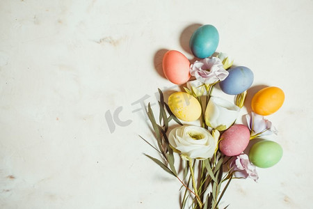 粉色梅布背景上的鲜花和鸡蛋，复制复活节问候的空间。鲜花和鸡蛋