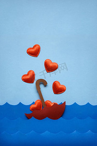创意情人节礼物概念照片，蓝色背景下，心漂浮在海面上。