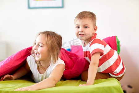 小孩子摄影照片_童年、休闲和家庭概念-快乐的小孩子躺在地板或地毯上。快乐的小孩子躺在地板或地毯上