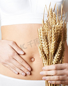 女人穿着内裤，抱着麦子，摸着肚子的特写