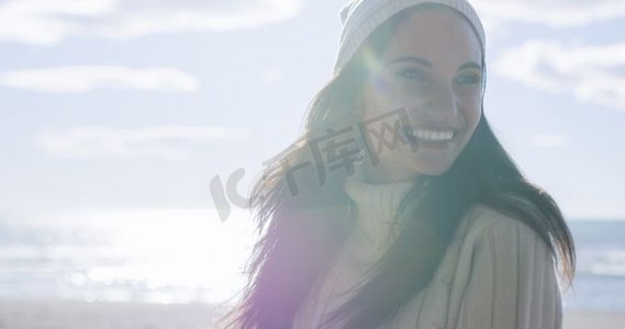 女装秋装新品摄影照片_一位身着秋装的年轻女子在海滩上微笑