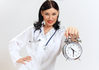 时间治愈摄影照片_带着钟表的年轻女医生。幸福成功的年轻女医生拿着时钟的肖像