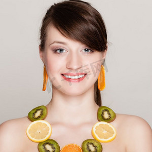 珠宝摄影照片_饮食.女孩与项链和耳环新鲜柑橘水果在灰色。女性推荐健康食品和营养。