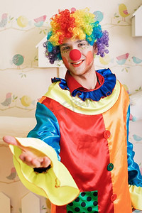 快乐的小丑红鼻子和五颜六色的服装提供友谊。