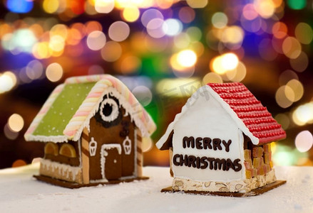 烹饪、度假和烘焙概念-圣诞灯饰背景下的姜饼屋。圣诞彩灯下的姜饼屋