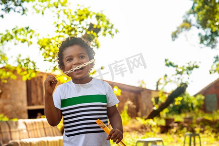 快乐的非洲小男孩在大自然中玩肥皂泡
