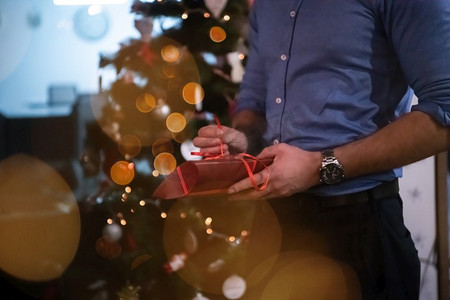 圣诞节和新年办公室派对概念商务人士打开礼品盒以圣诞树为背景关闭细节